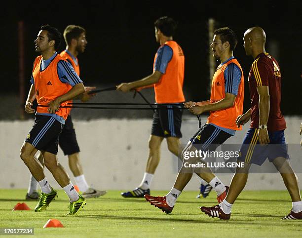 Spanish midfielder Xavi Hernandez and defender Cesar Aspilicueta take part in a training session at the Wilson Campos Training Center near Recife,...