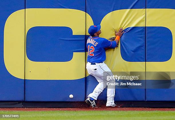 Juan Lagares of the New York Mets can't come up with a ball hit in the second inning for a three run triple by David DeJesus of the Chicago Cubs at...