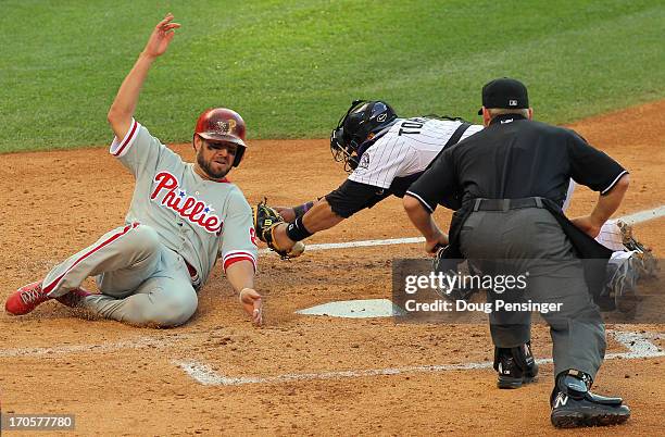 Kevin Frandsen of the Philadelphia Phillies slides home to score on a double by John Mayberry Jr. #15 of the Philadelphia Phillies around the tag of...