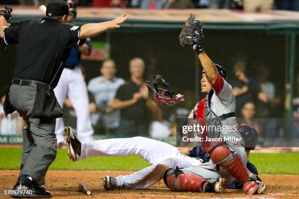 Home plate umpire Brian Knight signals safe after Drew Stubbs of the Cleveland Indians slid into catcher Kurt Suzuki of the Washington Nationals to...