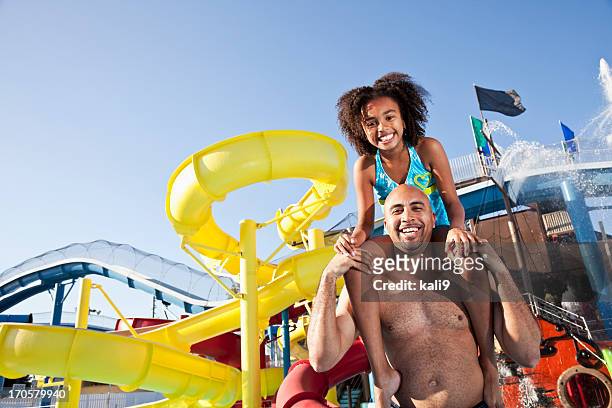 uma menina nos ombros do pai no parque aquático - parque de diversões edifício de entretenimento - fotografias e filmes do acervo