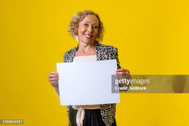senior woman holding blank sign - blank sign stock pictures, royalty-free photos & images