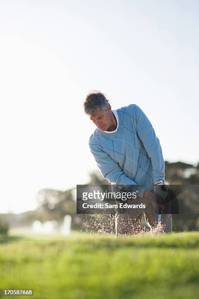 man playing golf in sand trap - golf bunker low angle stock pictures, royalty-free photos & images