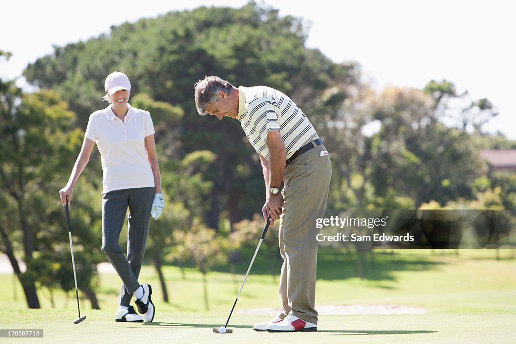 Mature couple playing golf together