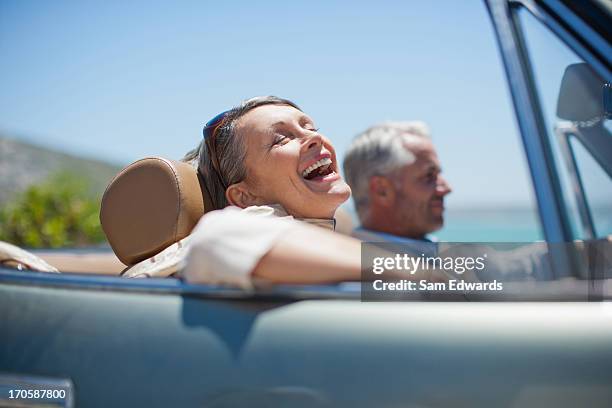 mature couple driving in convertible - fun to drive stockfoto's en -beelden