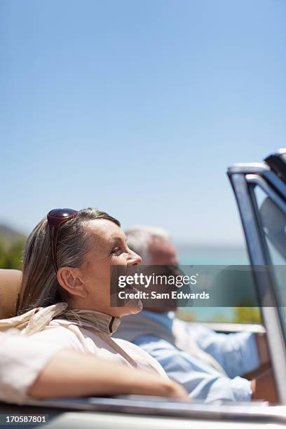 mature couple driving in convertible - couple in car smiling stock pictures, royalty-free photos & images