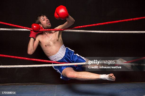 young man tangled up in boxing ring ropes - boxer knockout stock pictures, royalty-free photos & images