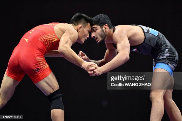 China's Li Lei competes against Iran's Seyed Danial Sohrabi in the men's 67kg greco-roman Bronze medal wrestling event during the 2022 Asian Games in...
