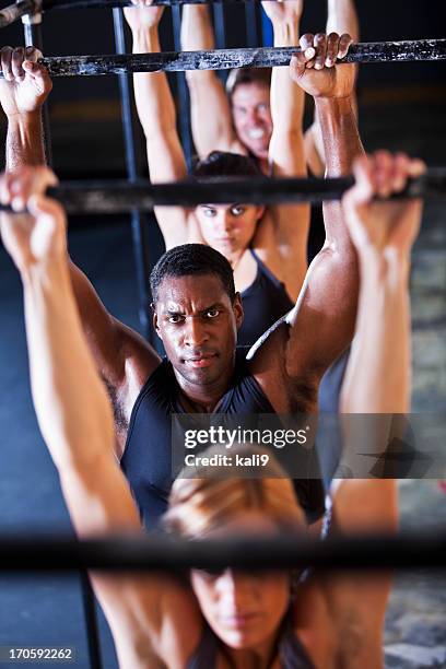 group of athletes in gym - man hanging from monkey bars stock pictures, royalty-free photos & images