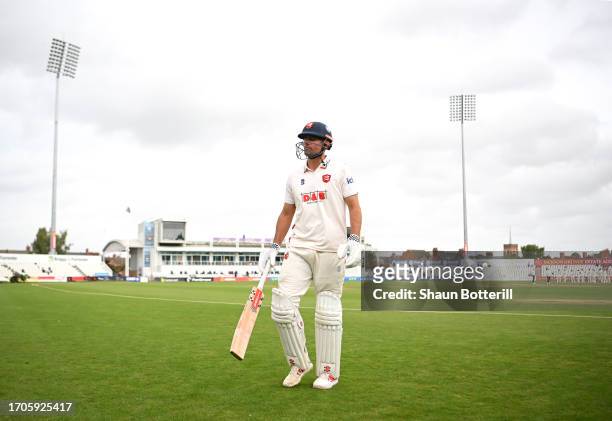 Sir Alastair Cook of Essex walks back to the pavilion after being caught by Lewis McManus of Northamptonshire off the bowling of Ben Sanderson during...