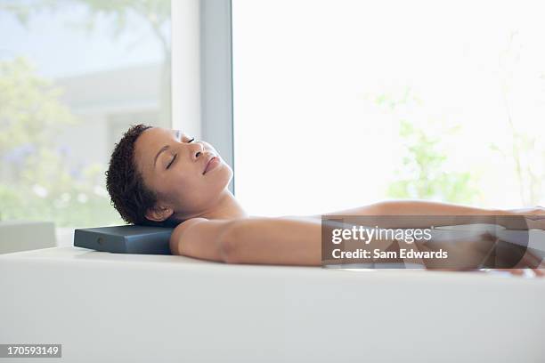 woman relaxing in bathtub - bad body language stockfoto's en -beelden