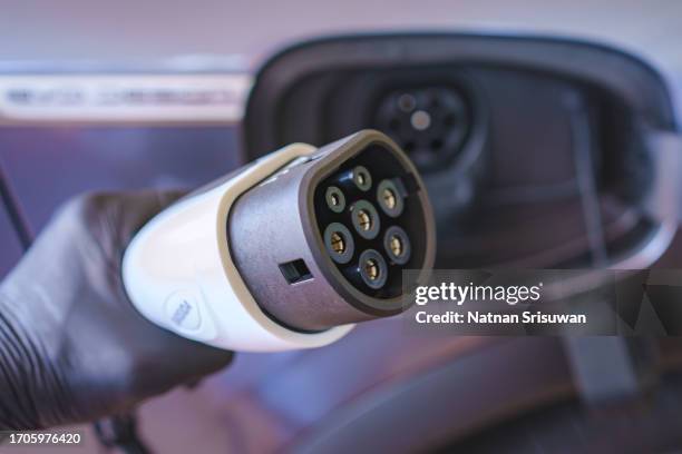 plugging in charging lead to electric car at home - lithium ion battery stock pictures, royalty-free photos & images