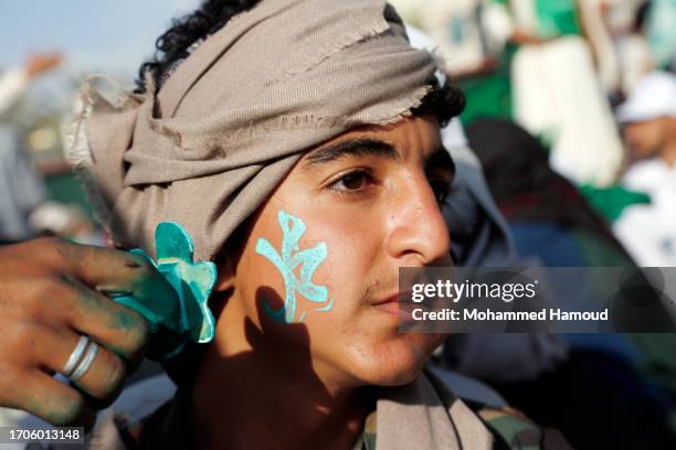 Man paints the name of Prophet Muhammed on the face of a child during the celebration of Mawlid which marks the birthday of the Islamic prophet...