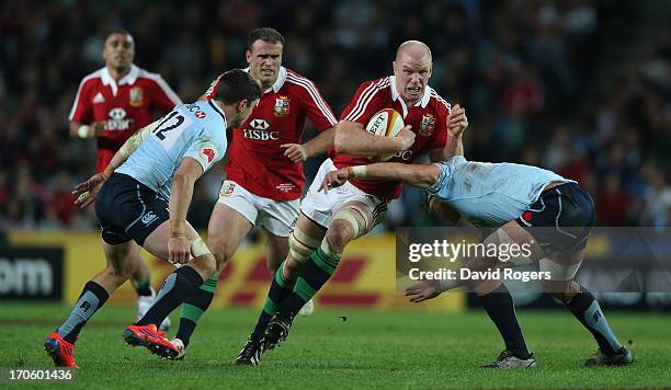 Paul O'Connell of the Lions is tackled by Tom Carter and Ollie Atkins during the match between the NSW Waratahs and the British & Irish Lions at...