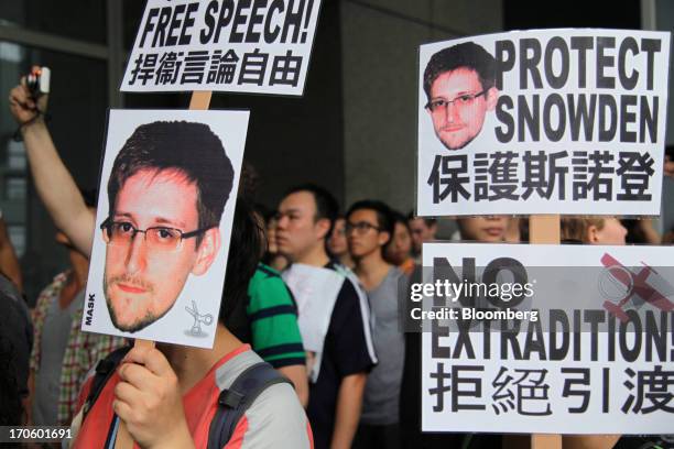 Protesters hold placards outside government headquarters during a rally in support of Edward Snowden, the former National Security Agency contractor,...