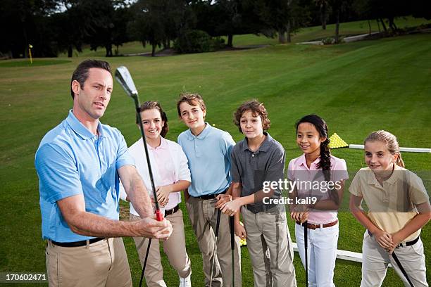 golf pro with group of children on driving range - golf lessons stock pictures, royalty-free photos & images