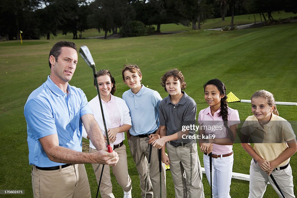 Golfe profissional com grupo de crianças no driving range