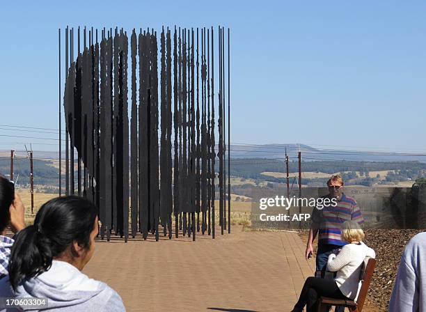 Tourists look at a monument dedicated to the 'capture site' of former South African President Nelson Mandela in Howick, approximately 150 kilometers...