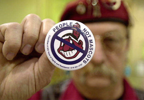 Powwow attendee Sonny Hensley holds an anti-mascot button to protest using Indians as mascots for sports teams at the 10th Annual New Years Eve...