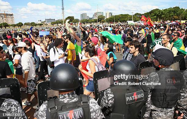 Security services watch protestors prior to the FIFA Confederations Cup Brazil 2013 Group A match between Brazil and Japan at National Stadium on...