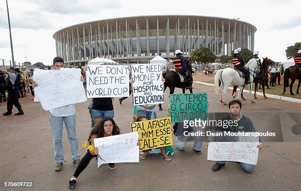 Protestors hold banners prior to the FIFA Confederations Cup Brazil 2013 Group A match between Brazil and Japan at National Stadium on June 15, 2013...