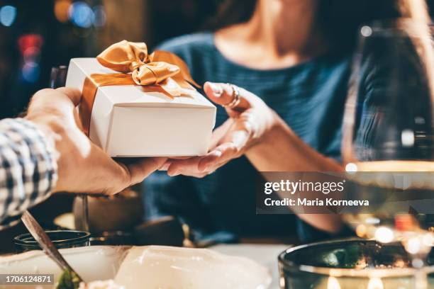 man giving small gift in restaurant. - package stock pictures, royalty-free photos & images