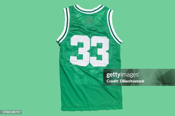 green basketball jersey with the number 33, on a green background. boston, basketball, sports equipment and legend concept. - basketbaltenue stockfoto's en -beelden