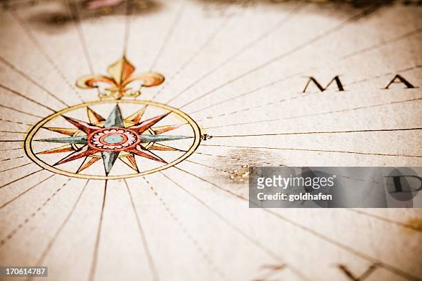 close up of antique style compass on old map - latitude stockfoto's en -beelden