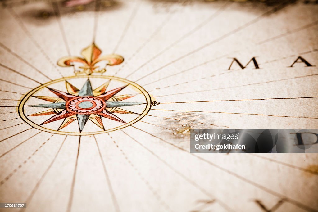Close up of antique style compass on old map