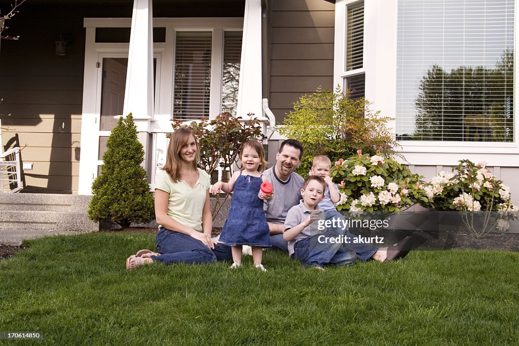 Heureuse famille assis devant leur domicile