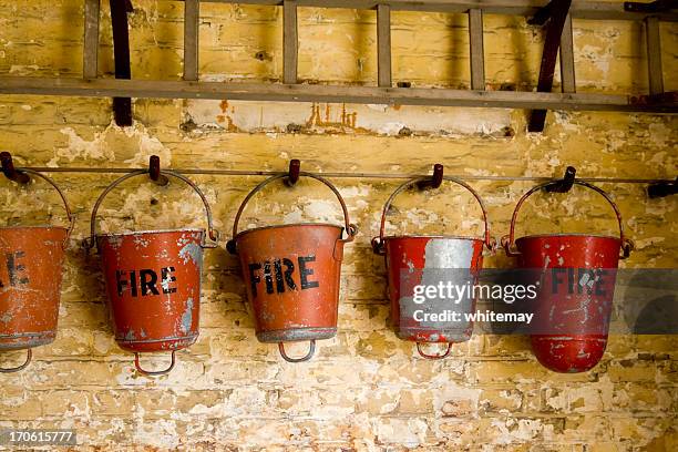 row of fire buckets - fire station wall stock pictures, royalty-free photos & images