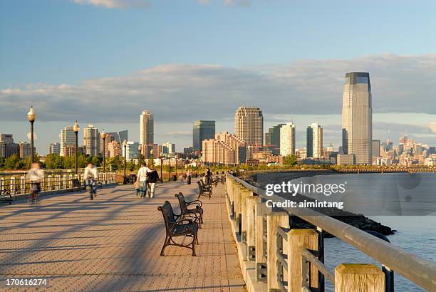 people in liberty park of new jersey at sunset - new jersey boardwalk stock pictures, royalty-free photos & images