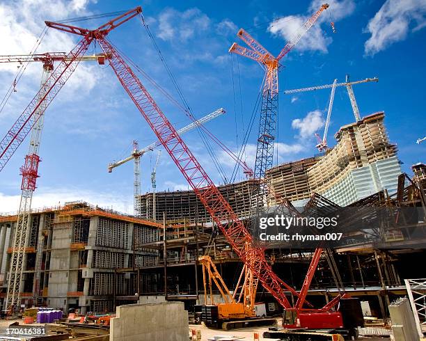 two construction cranes on a large work site - hotel building stock pictures, royalty-free photos & images