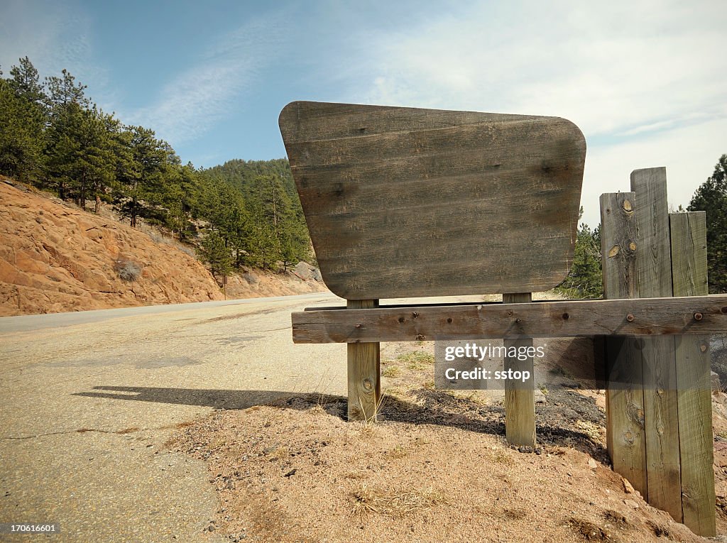 A weather worn sign on a dirt road