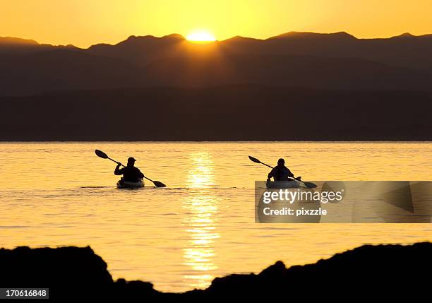 kayaking sporty outdoor couple sea-canoeing at sunset - sea of cortes stock pictures, royalty-free photos & images