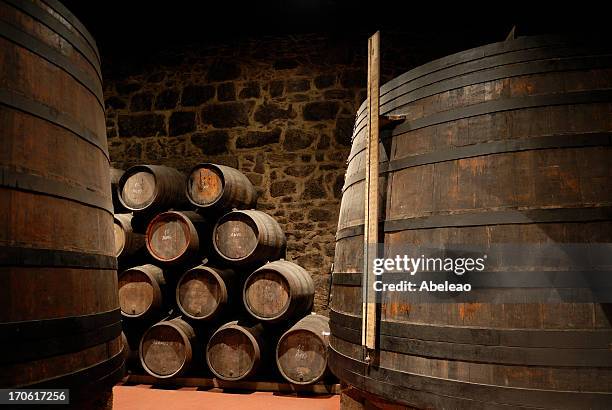 wine cellar with stacked wine barrels - porto portugal wine stock pictures, royalty-free photos & images