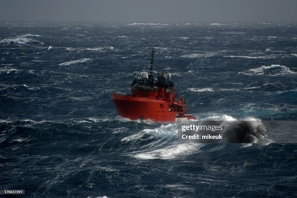 Red boat in the sea during a storm