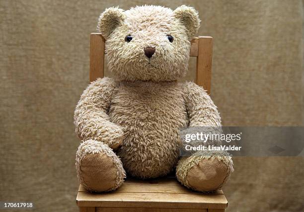 old teddy bear sitting on wooden chair - toy animal stock pictures, royalty-free photos & images