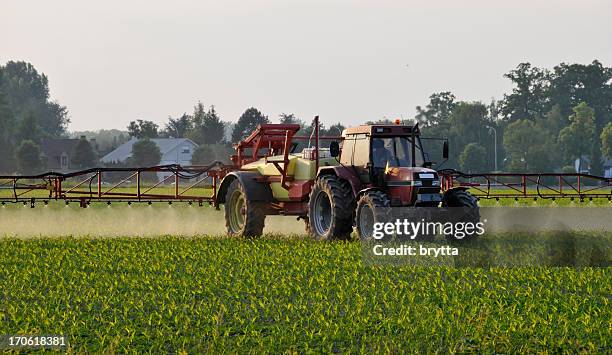 agricultural machinery spraying the crops with pesticides in springtime, belgium. - sproeier stockfoto's en -beelden