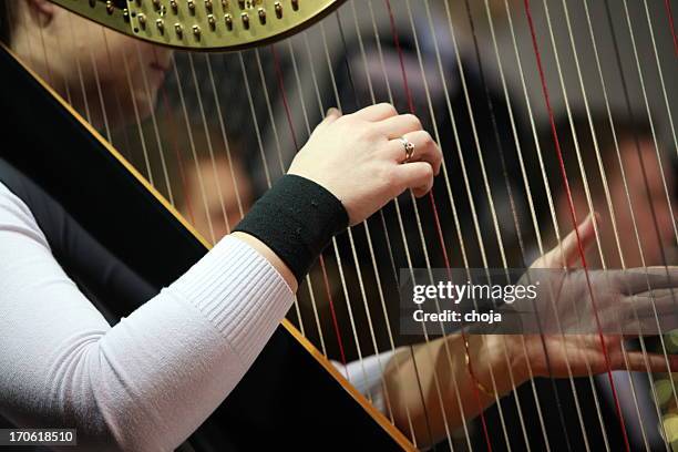 harpist tocar em concert.orchestra na parte de trás - harpa imagens e fotografias de stock