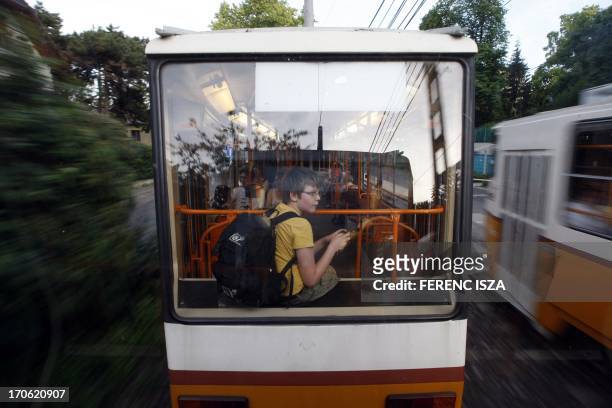 Hungarian pupil Csongor uses the tram to turn back home after school in Budapest on June 15, 2013. AFP PHOTO / FERENC ISZA