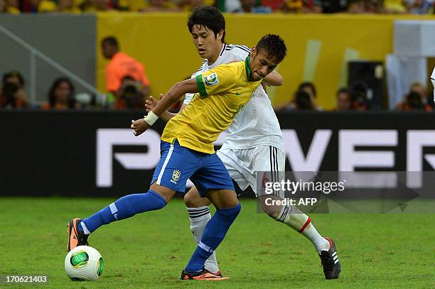 Brazil's forward Neymar is marked by Japan's defender Atsuto Uchida during their FIFA Confederations Cup Brazil 2013 Group A football match, at the...