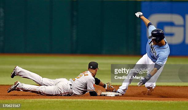Infielder Alexi Casilla of the Baltimore Orioles tags out Desmond Jennings of the Tampa Bay Rays on a steal attempt during the game at Tropicana...