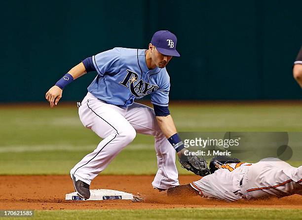 Infielder Sean Rodriguez of the Tampa Bay Rays tags out Alexi Casilla of the Baltimore Orioles on a steal attempt during the game at Tropicana Field...