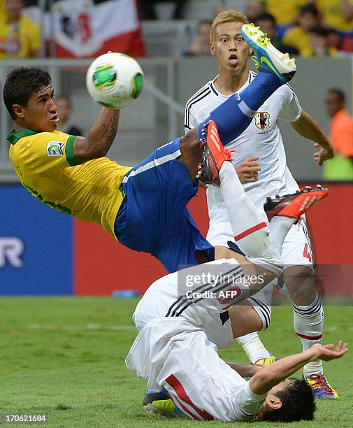 Japan's midfielder Shinji Kagawa and Brazil's midfielder Paulinho fall as Japan's midfielder Keisuke Honda looks on during their FIFA Confederations...