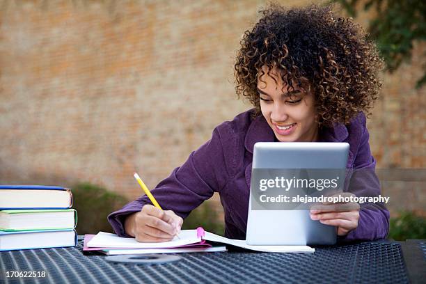 a happy young girl using a tablet - cute college girl stock pictures, royalty-free photos & images