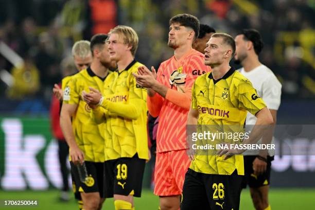Dortmund's Norwegian defender Julian Ryerson, Dortmund's Swiss goalkeeper Gregor Kobel and Dortmund's German midfielder Julian Brandt react at the...