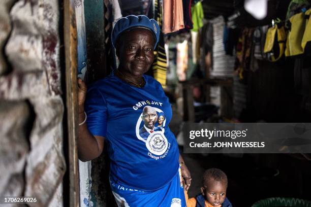 Cathrine, poses for a picture with a t-shirt of the President of Liberia George Weah on it in Clara town, Monrovia on October 4, 2023. Liberia is...