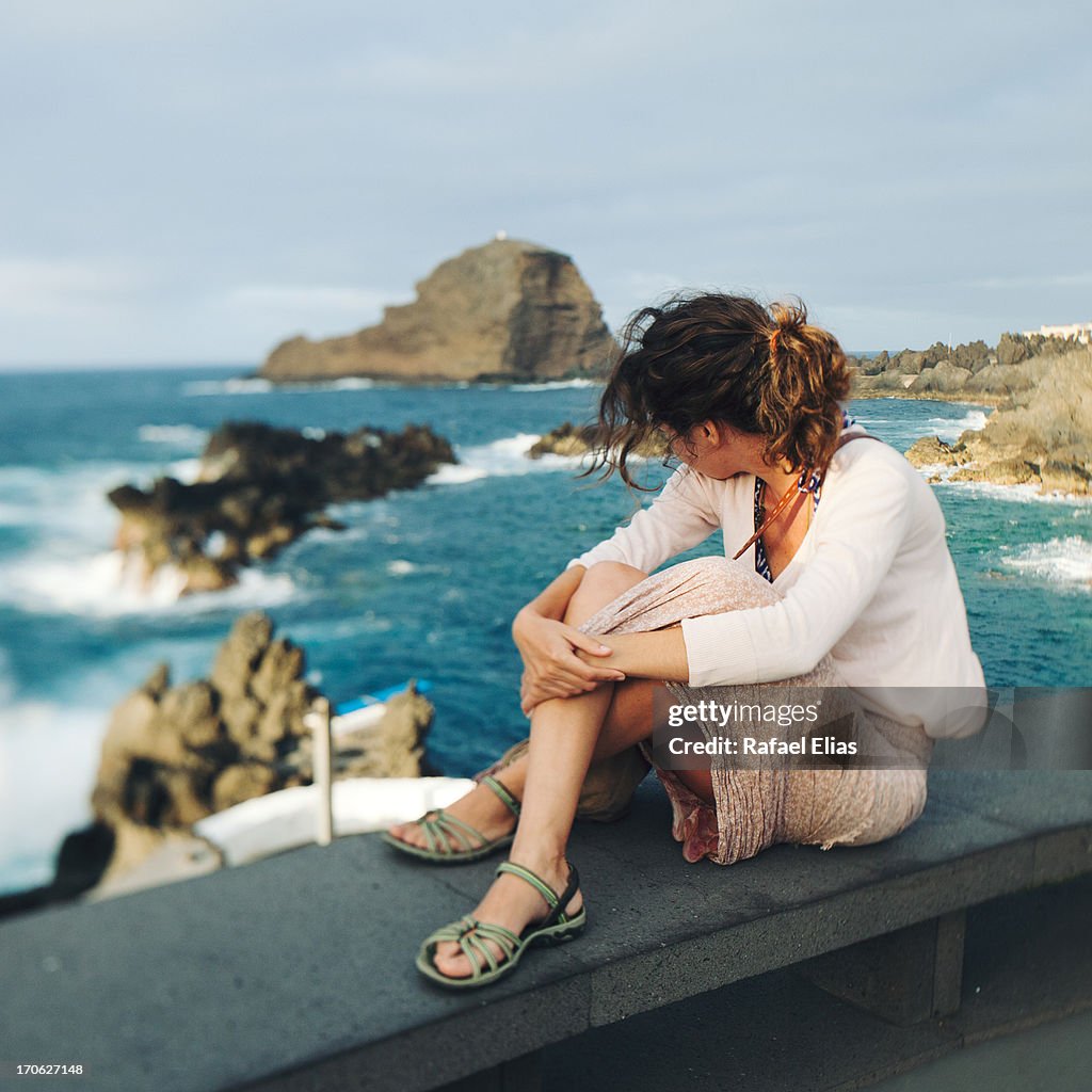 Young woman sitting on seaside breakwater