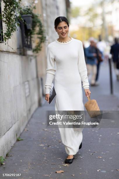 Guest is seen wearing a gold chain necklace, a white long sleeves long dress, a beige suede sequins bag, black leather ballerinas outside the Rabanne...